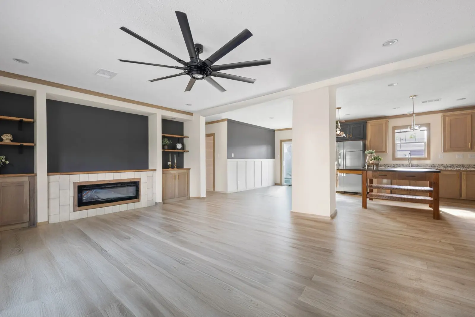 Open living area with built-in shelving and electric fireplace