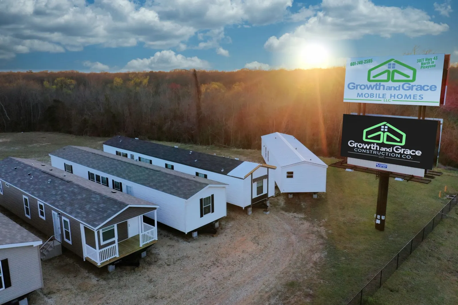 Aerial view of the Growth and Grace Mobile Homes lot on Highway 43 North at sunset, with homes on display beside the company sign